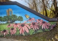 Mural on underpass featuring historic buildings and a message to `Keep Denton Beautiful` by muralist Dan Colcer.