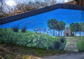 Mural on underpass featuring historic buildings and a message to `Keep Denton Beautiful` by muralist Dan Colcer.