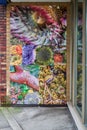 A mural of vibrant colourful sea creatures painted on a downtown business wall.
