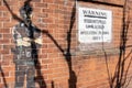 Mural and a warning sign on a wall in Newcastle upon Tyne, about 'stereotypical lookalikes' in area