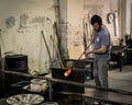 Glassblowing artisan at work in a crystal glass workshop in Murano island, Venice, Italy.