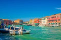 Murano islands with bridge across water canal, boats and motor boats, colorful traditional buildings, Venetian Lagoon