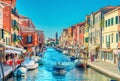 Murano islands, bridge across water canal, boats and motor boats, colorful traditional buildings, Venetian Lagoon