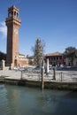 Murano, Italy, glass bottle Christmas tree in plaza in front of bell brick tower with clock Royalty Free Stock Photo