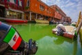 MURANO, ITALY - JUNE 16, 2015: Italy flag and shield on a boat engine above a green water in Murano canals