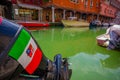 MURANO, ITALY - JUNE 16, 2015: Italy flag and shield on a boat engine above a green water in Murano canals