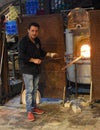 Murano glass worker heating glass in furnace