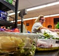 Shopper paying for products at checkout. Foods on conveyor belt at the supermarket