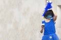 Murcia, Spain, April 25, 2019: A woman disguised as a smurf drinking a beer marching at annual parade festival, party, celebration