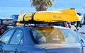 Murcia, Spain, August 20, 2019: Yellow kayak with tied on car roof racks against palm trees and the seascape Royalty Free Stock Photo