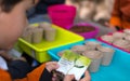 Murcia, Spain, February 5, 2020: Young children learning how to plant seeds in garden. Hands holding seeds and black soil in pot.