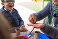 Murcia, Spain, February 5, 2020: Young children learning how to plant seeds in garden. Hands holding seeds and black soil in pot.