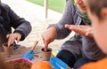 Murcia, Spain, February 5, 2020: Young children learning how to plant seeds in garden. Hands holding seeds and black soil in pot.