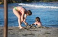 Murcia, Spain, July 18, 2019: Mother and child daughter play at the beach.
