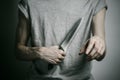 Murder and Halloween theme: a man holding a knife on a gray background Royalty Free Stock Photo