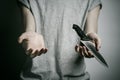 Murder and Halloween theme: a man holding a knife on a gray background Royalty Free Stock Photo