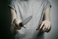 Murder and Halloween theme: a man holding a knife on a gray background Royalty Free Stock Photo