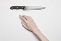 Murder and Halloween theme: A man's hand reaching for a knife, a human hand holding a knife isolated on a gray background in Royalty Free Stock Photo