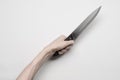 Murder and Halloween theme: A man's hand reaching for a knife, a human hand holding a knife isolated on a gray background in Royalty Free Stock Photo