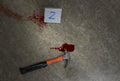 Murder weapon hammer, blood of victim and evidence marker on floor Royalty Free Stock Photo