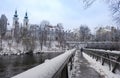 Mur river with Murinsel bridge and Mariahilfer church in the background, in Graz, Styria region, Austria, with snow, in winter