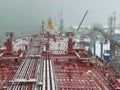 Oil tanker being oil pumped at sea port at winter