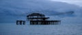 Murmuration of starlings over the remains of West Pier, Brighton UK. Photographed at dusk. Royalty Free Stock Photo