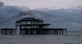 Murmuration of starlings over the remains of West Pier, Brighton UK. Photographed at dusk. Royalty Free Stock Photo