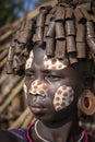 Girl from the Suri tribe poses for a photo with a traditionally painted face. Ethiopia