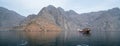 Musandam, Oman - 04.01.2018: People on a traditional arabian dhow boat sailing in the fjords of Musandam, Oman. Hazy day Royalty Free Stock Photo