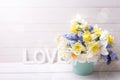 Muscaries and yellow narcissus flowers in blue bucket and word