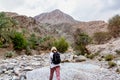 Muscat, Oman - December 16, 2018: female tourist is walking along the wadi - a dried up riverbed - in the outskirts of Muscat