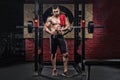 Muscle athlete man in gym making elevations. Bodybuilder training in gym Royalty Free Stock Photo