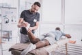 Serious young medical worker examining injured foot