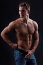 Muscle naked young man posing in jeans