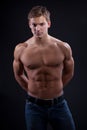 Muscle naked young man posing in jeans