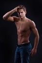 Muscle naked young man posing in jeans