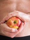 Muscle naked young man torso red apple in hands Royalty Free Stock Photo