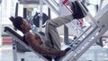 Muscular African fitness man exercising on leg press machine at the gym Royalty Free Stock Photo