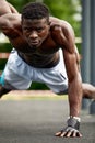 Muscular african man doing push ups in the park. Strong male athlete working out outdoors. Royalty Free Stock Photo