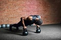 Muscular african man doing push ups against dark background.