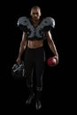 Muscular American football player holding football and head gear in his hand Royalty Free Stock Photo