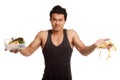 Muscular Asian man diet with measuring tape and clean food Royalty Free Stock Photo