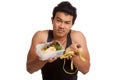 Muscular Asian man diet with measuring tape and clean food Royalty Free Stock Photo