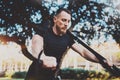 Muscular athlete exercising trx push up outside in sunny park.Fit shirtless male fitness model in crossfit exercise Royalty Free Stock Photo