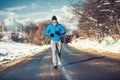 Muscular athlete man jogging outdoor on snow, training