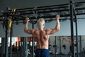 Muscular athlete man making Pull-up in gym. Bodybuilder training in fitness club showing his perfect back and shoulder Royalty Free Stock Photo