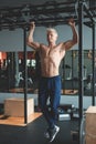 Muscular athlete man making Pull-up in gym. Bodybuilder training in fitness club showing his perfect back and shoulder Royalty Free Stock Photo