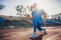 Muscular athlete young male stretching his leg on a running track in stadium, preparing for running and jogging. Caucasian man Royalty Free Stock Photo
