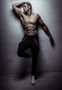 Muscular athlete young man posing over light gray wall